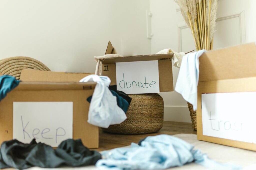 Three boxes, one that says 'keep', one that says 'donate' and one that says 'trash'. These boxes symbolize decluttering which is the second step in having a no-buy year. 
