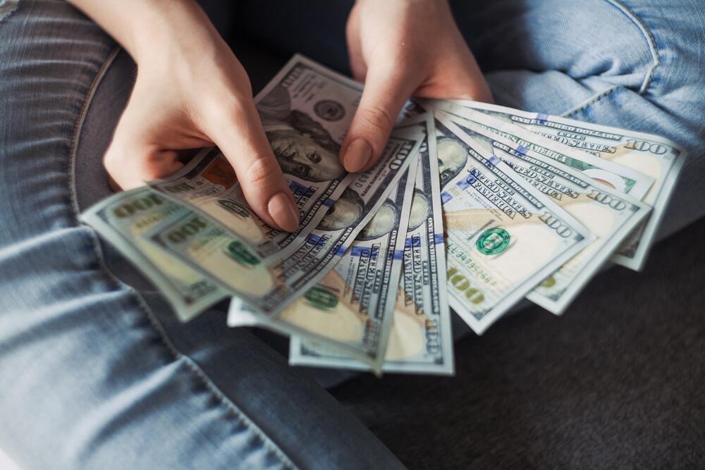 An image of someone holding cash in their hand as a symbol of improving their finances with minimalism 