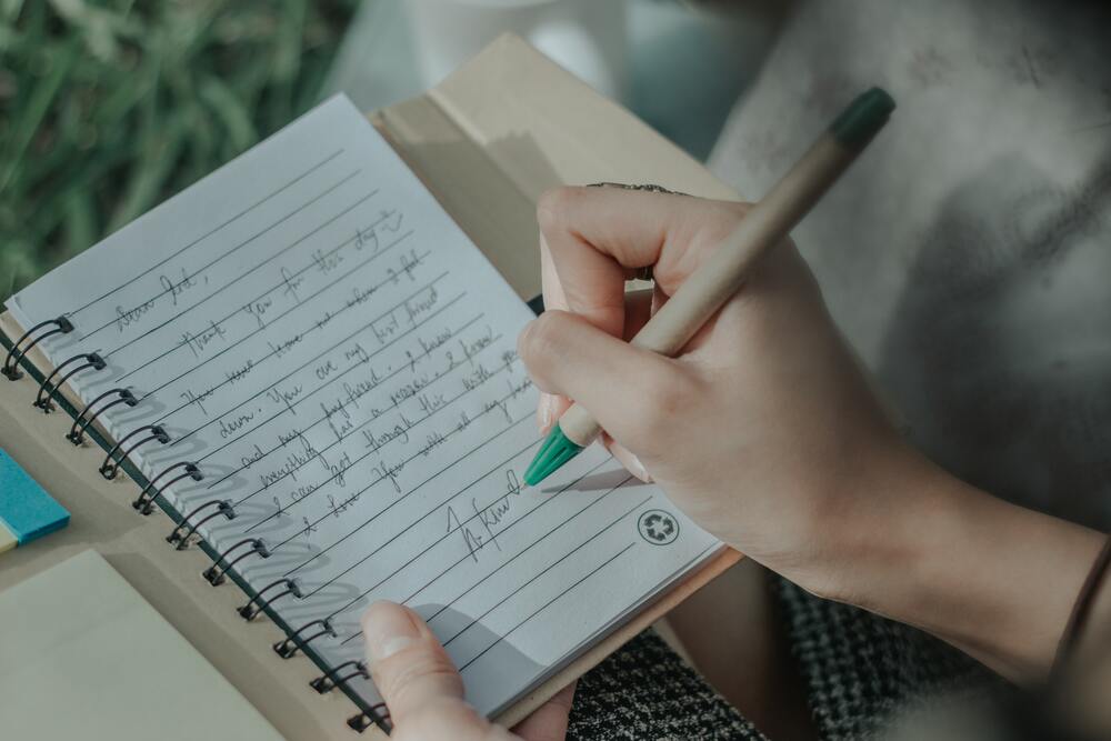 a close up image of a person journaling that represents a tip for how to budget money