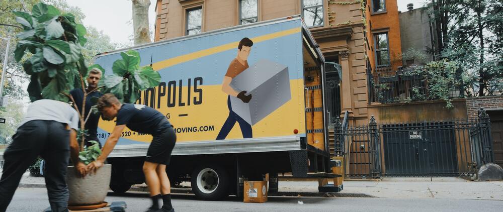 people putting things in a moving truck about to travel cross-country