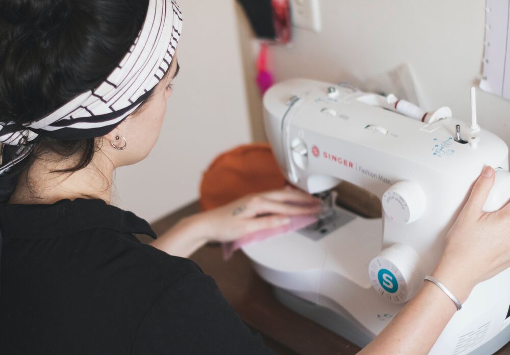an image of a person sewing that represents a tip for how to budget money