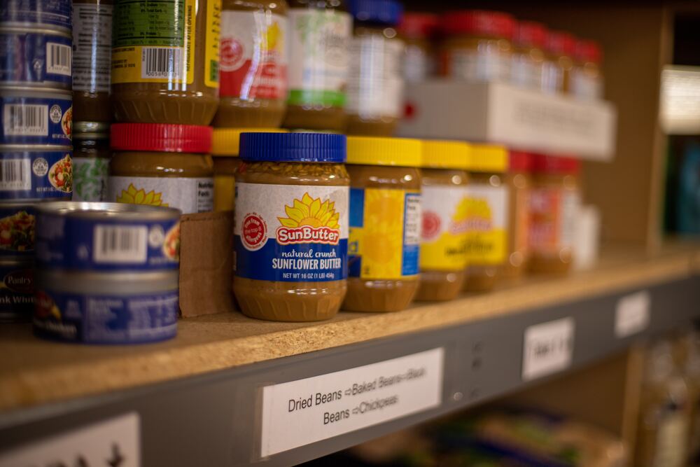 An image of sunflower seed butter jars on a shelf that represent making use of food pantries which is one of many unusual frugal tips shared in this blog post.