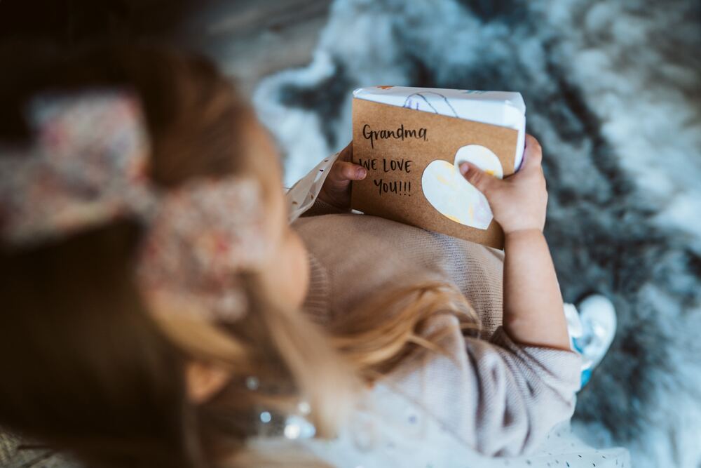 A little girl holding a handmade book for her grandma
