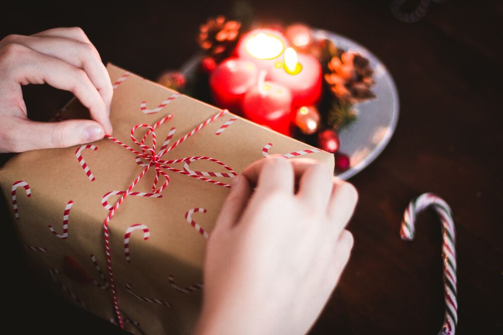A person wrapping a bow around a present