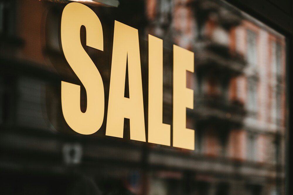 A yellow sale sign in a store front